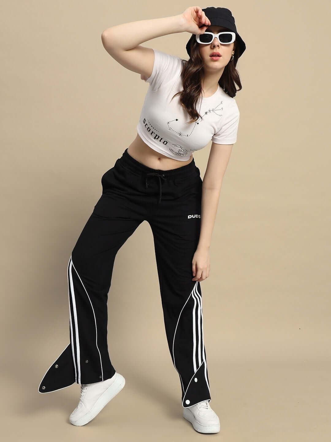Model wearing women's ripple contrast joggers in black, styled with white sneakers and a graphic crop top.