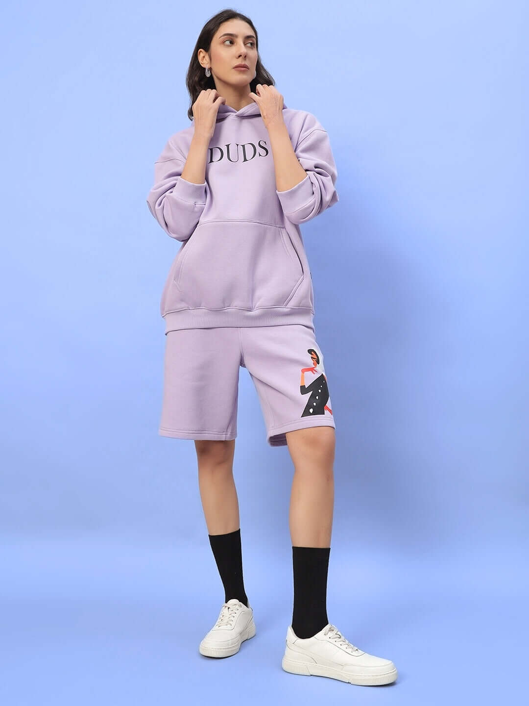 Woman wearing WOMEN RITZY FLEECE CO-ORD LILAC, featuring a matching lilac hoodie and shorts set by DUDS.
