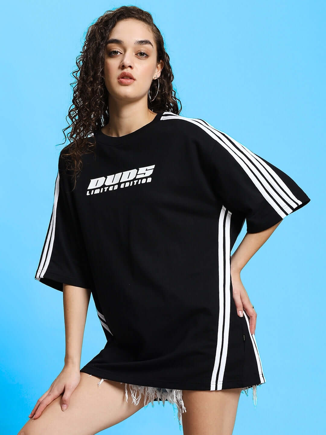 Woman wearing oversized black Roddy t-shirt with white stripes, made from premium cotton, styled in a sporty, casual look.