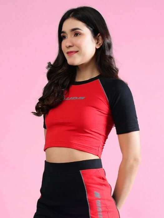 Woman wearing a red and black color-block crop top made of premium cotton, showcasing casual fashion simplicity.