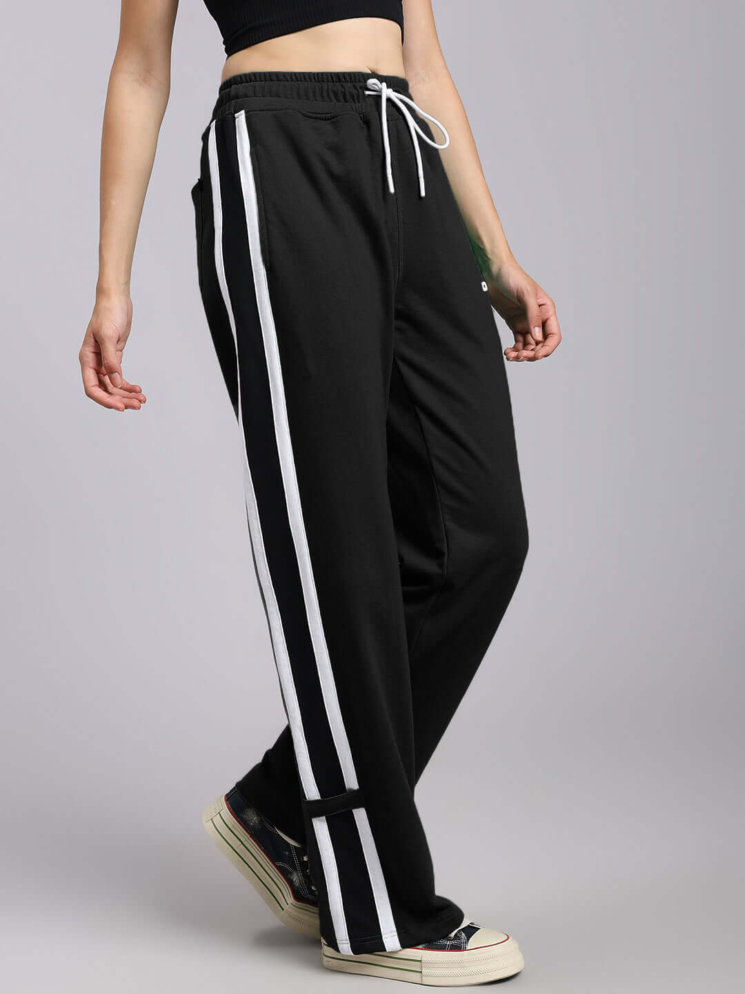 Woman wearing women's black Rosston relaxed fit joggers with white stripes, made to order by DUDS.