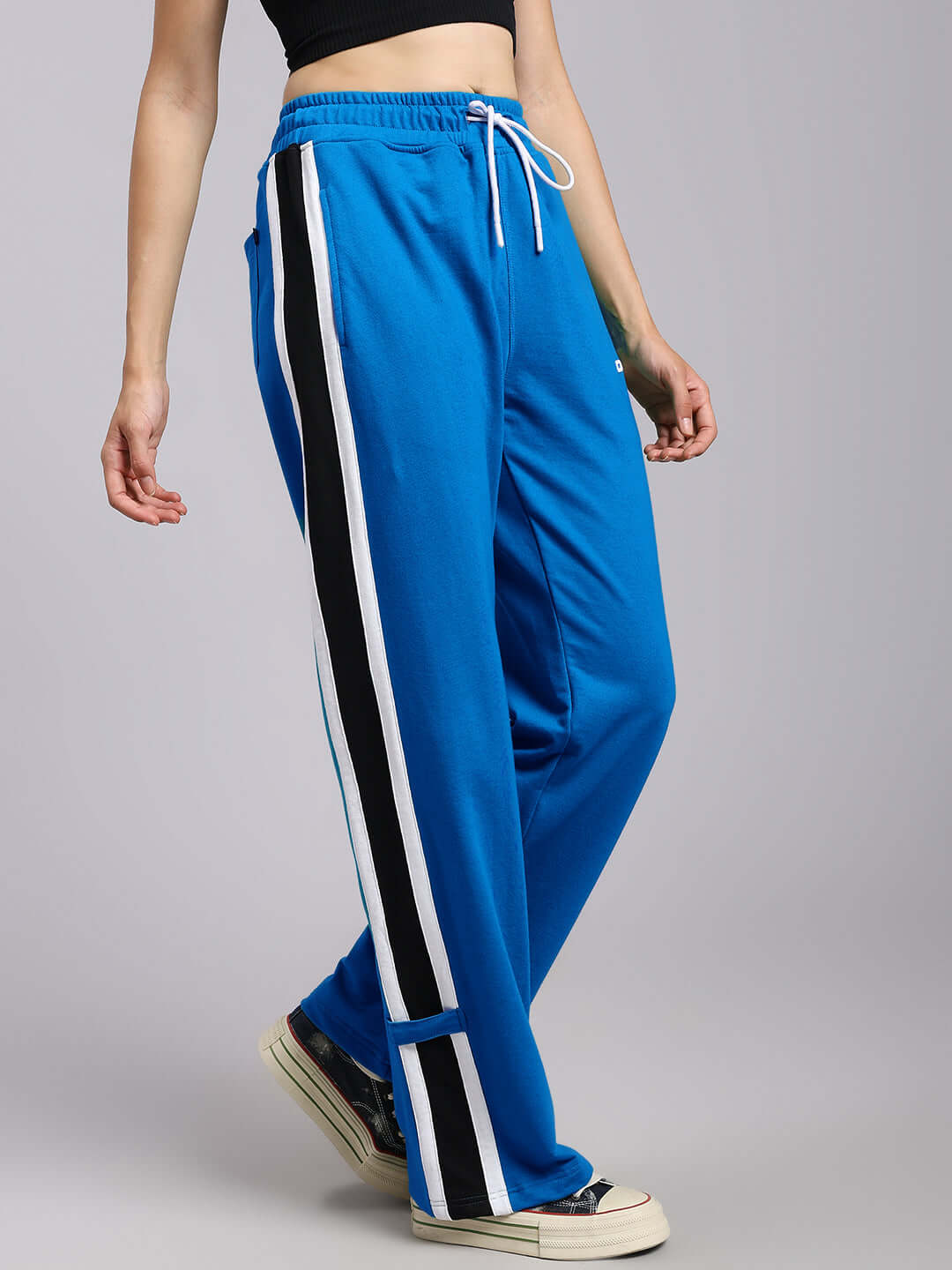 Woman wearing WOMENS ROSSTON FLAT-OUT RELAXED FIT JOGGERS BLUE with side stripe detail, showcasing bold streetwear style.