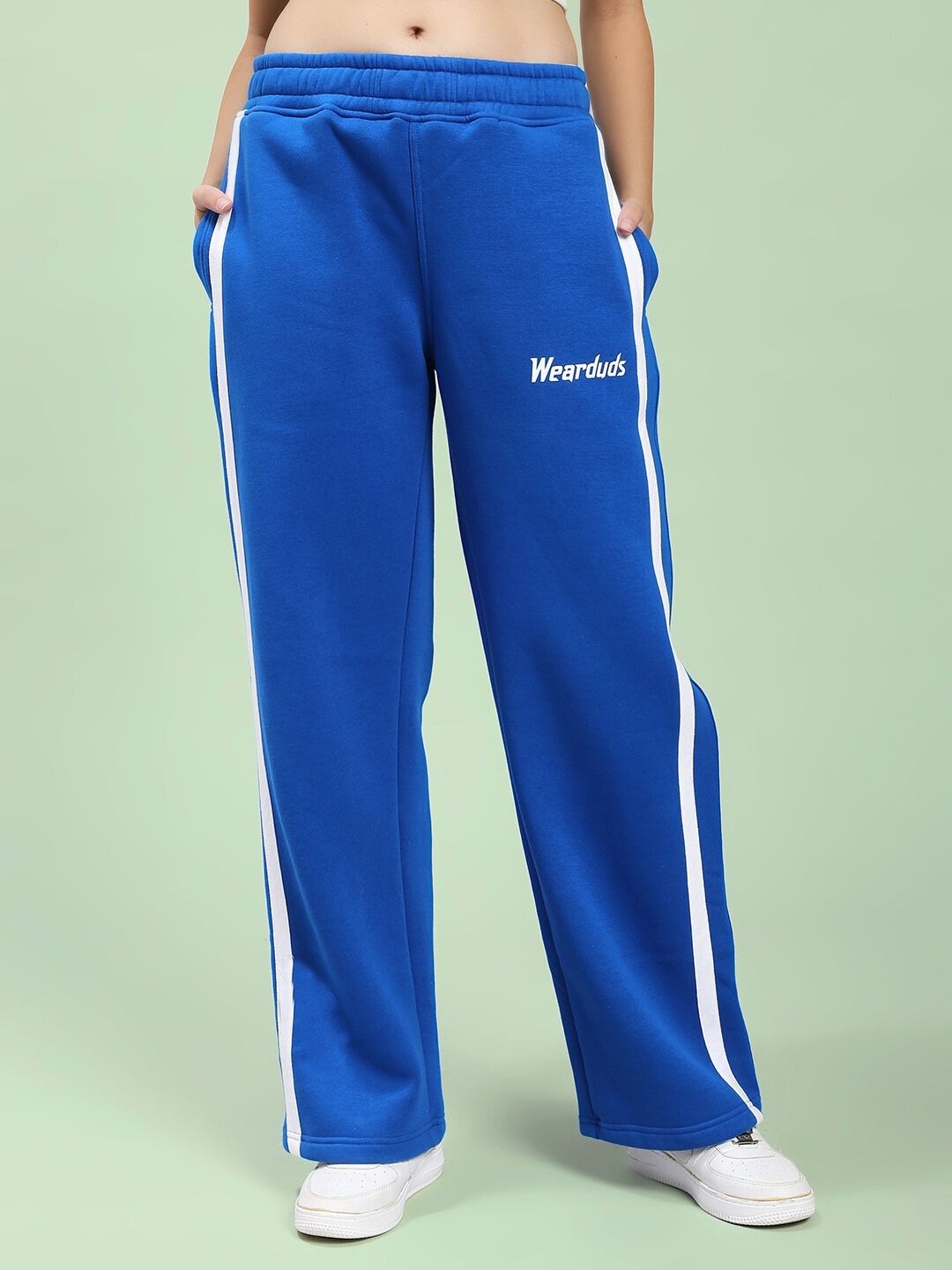Model wearing WOMEN RAPID STRIDE ROYAL BLUE COTTON FLEECE CO-ORD SET pants with white stripe design.