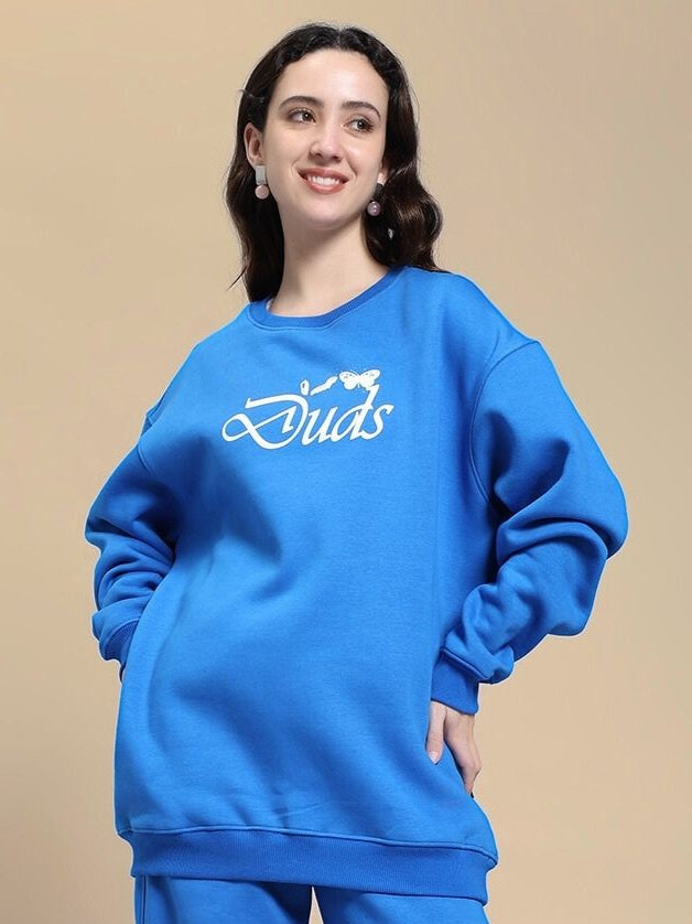 Woman wearing WOMEN'S NATURE LINK FLEECE SWEATSHIRT ROYAL BLUE and smiling against beige backdrop.