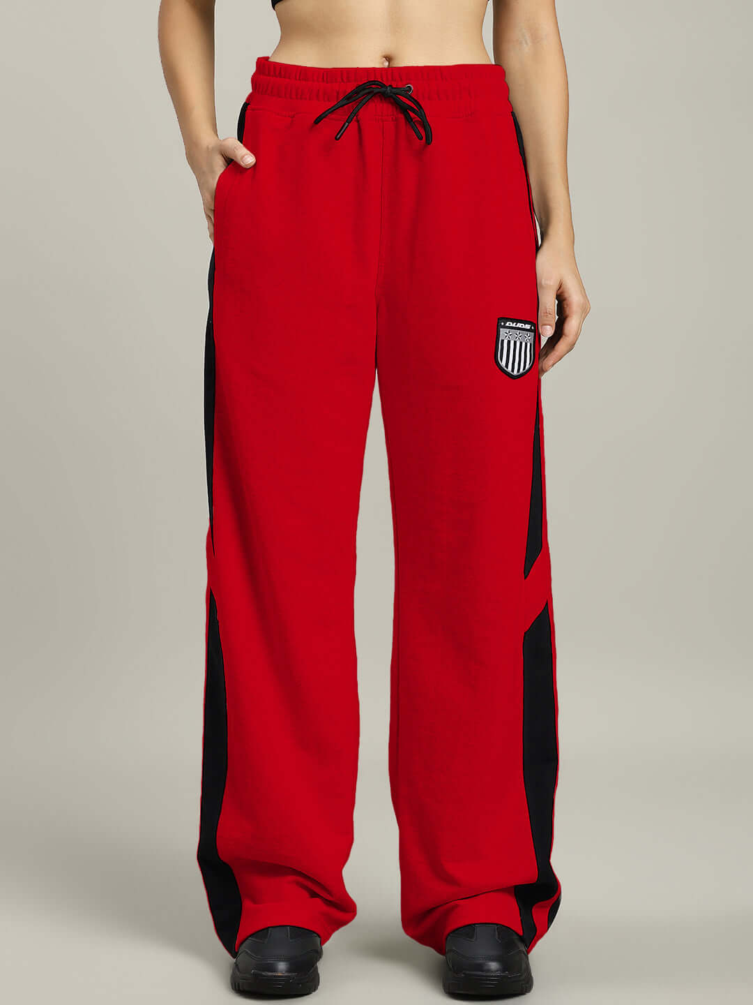 Women's red joggers by DUDS, made to order with customizable fit, featuring black accents and logo. Tailored for comfort and style.