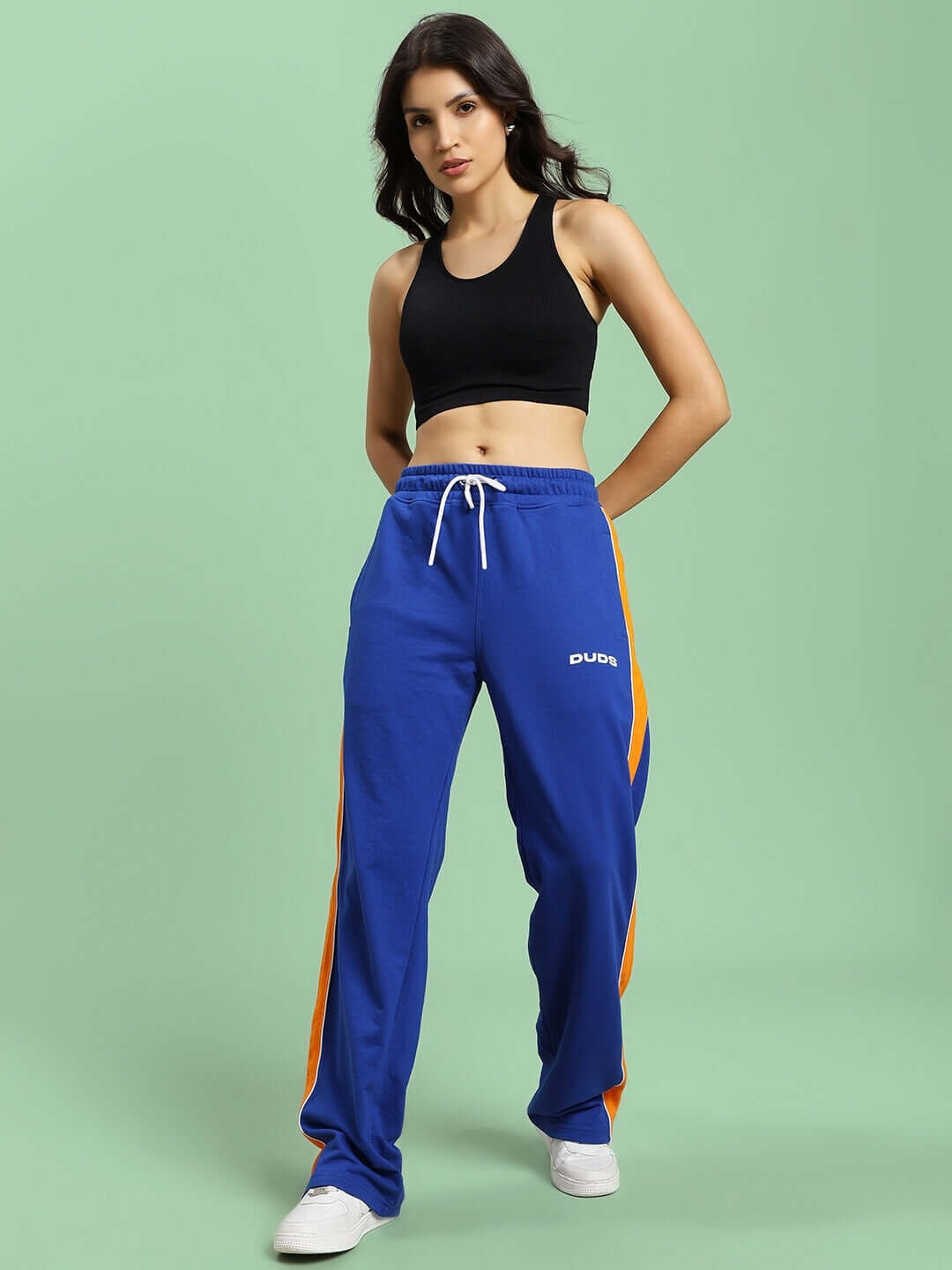 Model wearing WOMEN'S SANFORD STRIPE JOGGERS BLUE, featuring orange stripes, made by DUDS, with customizable fit options.