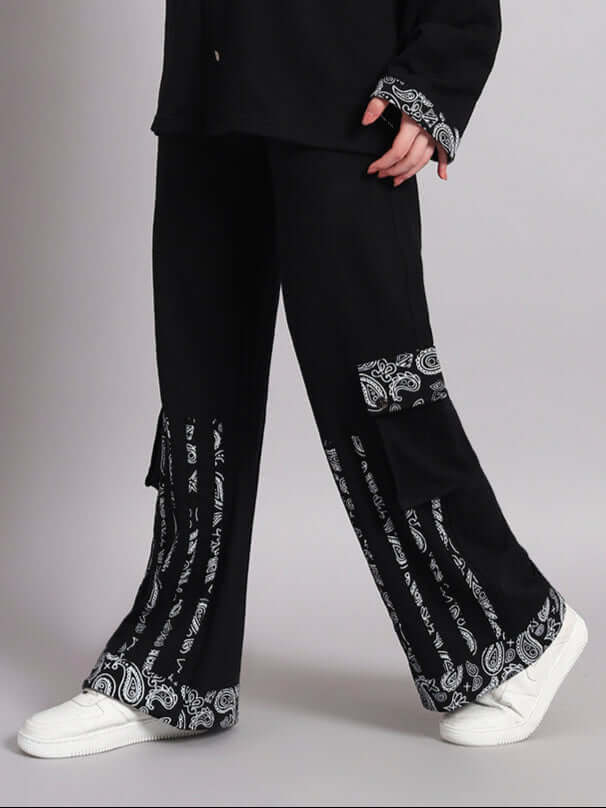 Women's Sanganeri joggers in black featuring patterned details, paired with white sneakers.