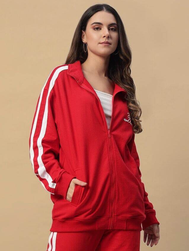 Woman wearing a red Women's Scotia Jacket by DUDS, featuring white stripes and zip-up design.
