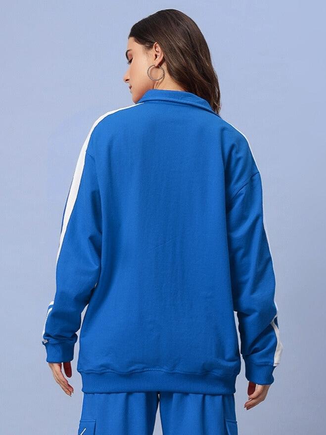 Woman wearing a royal blue Scotia jacket with white stripes, showcasing the back design. Perfect for custom fit options by DUDS.
