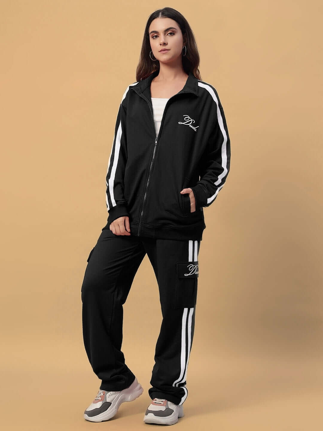 Woman wearing black DUDS Scotia jacket with white stripe details, showcasing a trendy and customizable outerwear option.