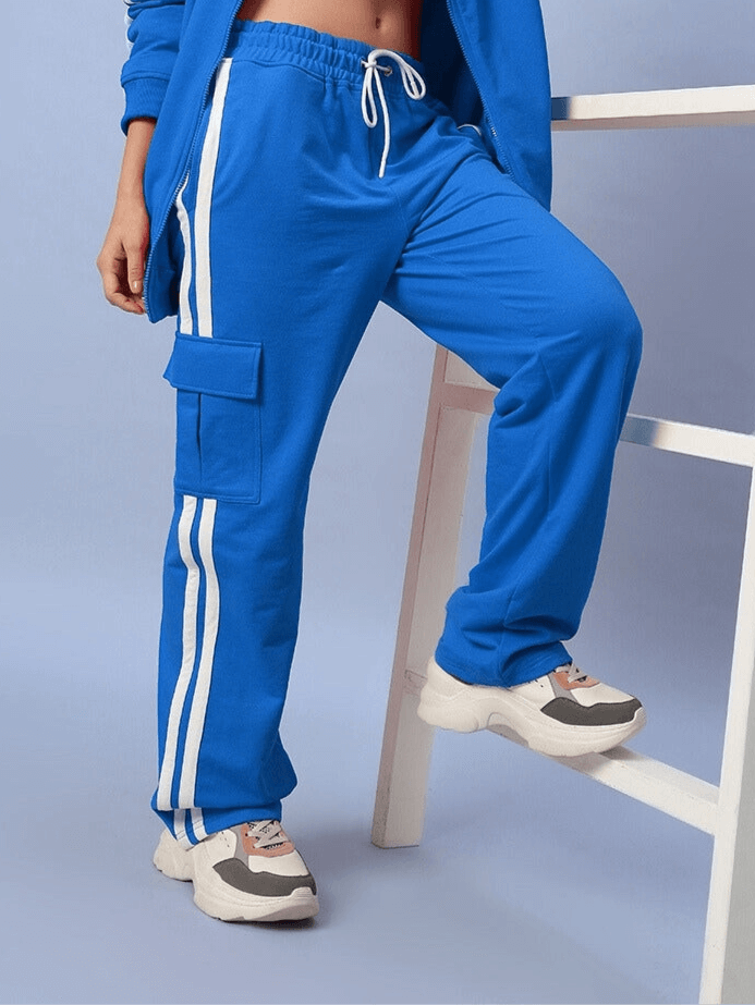 Woman wearing royal blue joggers with white stripes, showcasing Women's Scotia Stripe Joggers by DUDS.