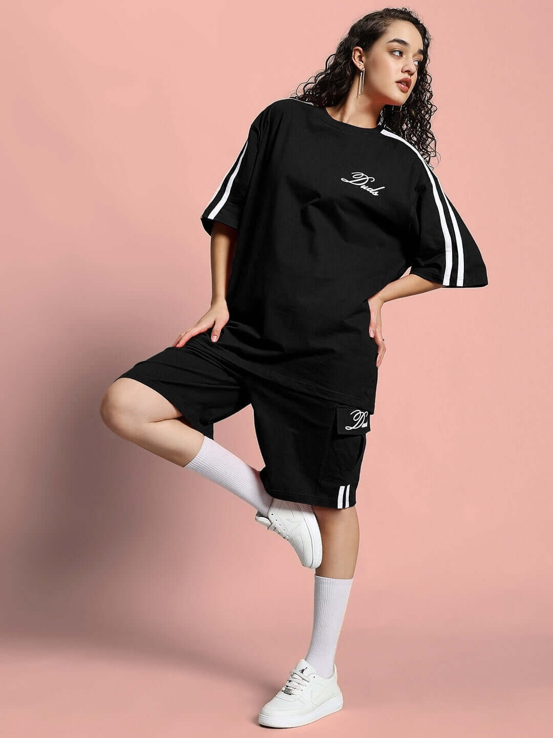 Model wearing WOMEN'S SCOTIA SUMMER CO-ORD SET BLACK, showcasing trendy casual summer fashion on a pastel background.
