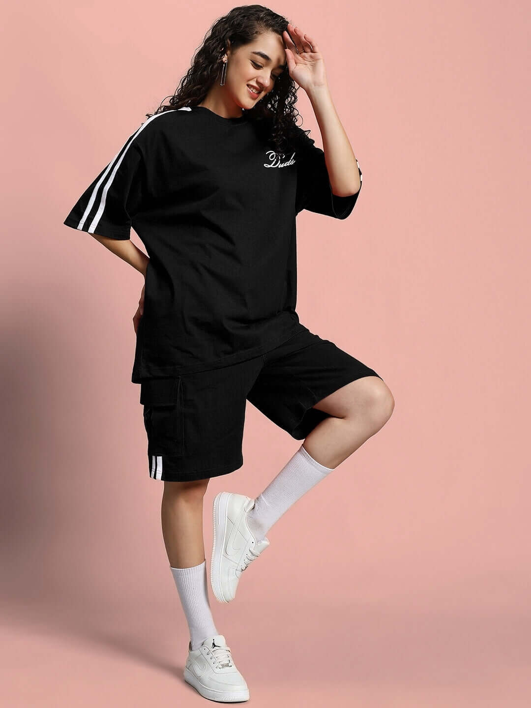 Woman wearing WOMEN'S SCOTIA SUMMER CO-ORD SET BLACK, posing against a pink background, highlighting style and comfort.