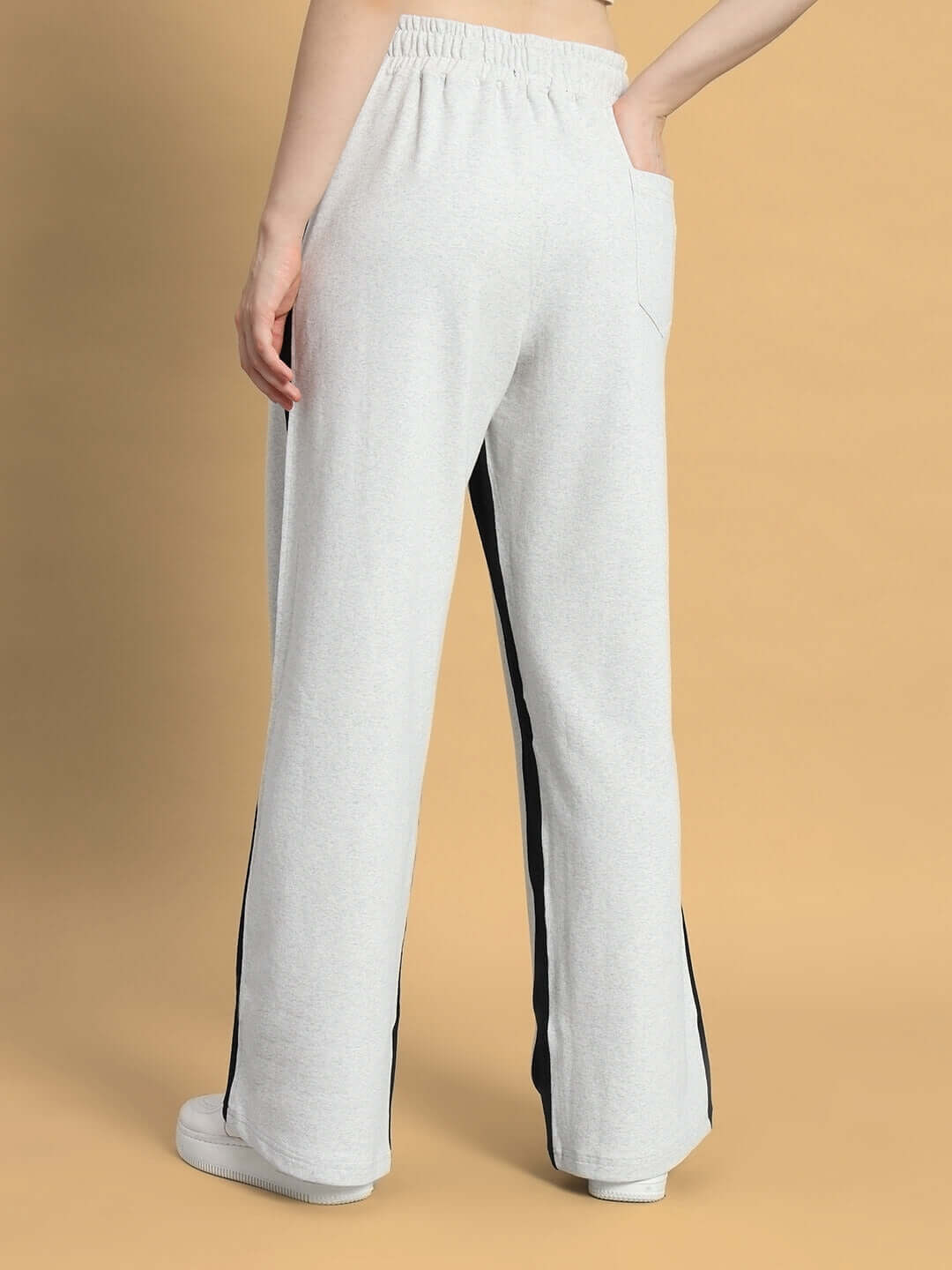 Back view of women's melange grey-black baggy joggers with side seams, highlighting comfortable fit and casual style.