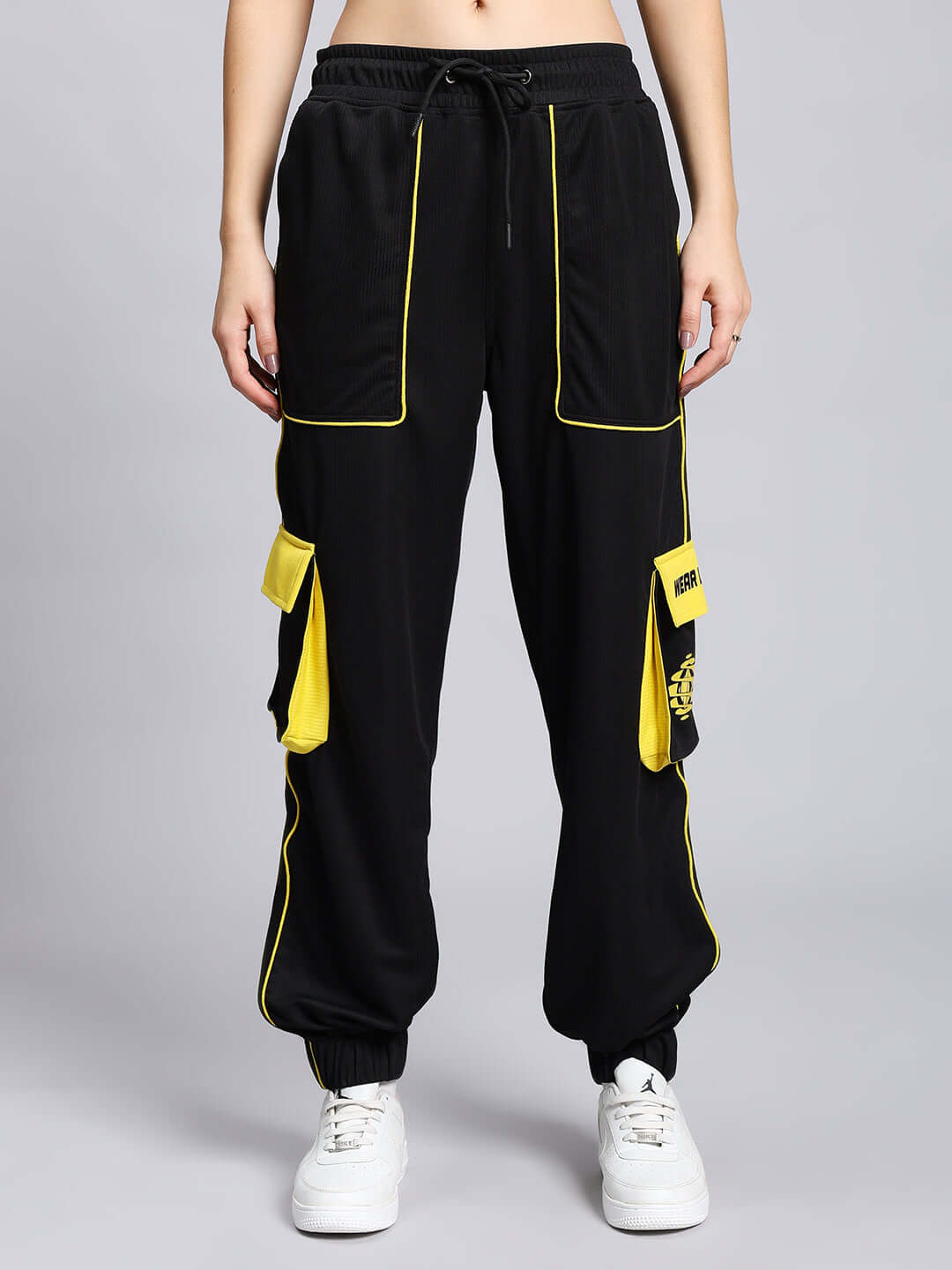 Alt Tag: Women's black soccer cargo jogger pants with yellow detailing, regular fit, made-to-order by DUDS, worn by a model.