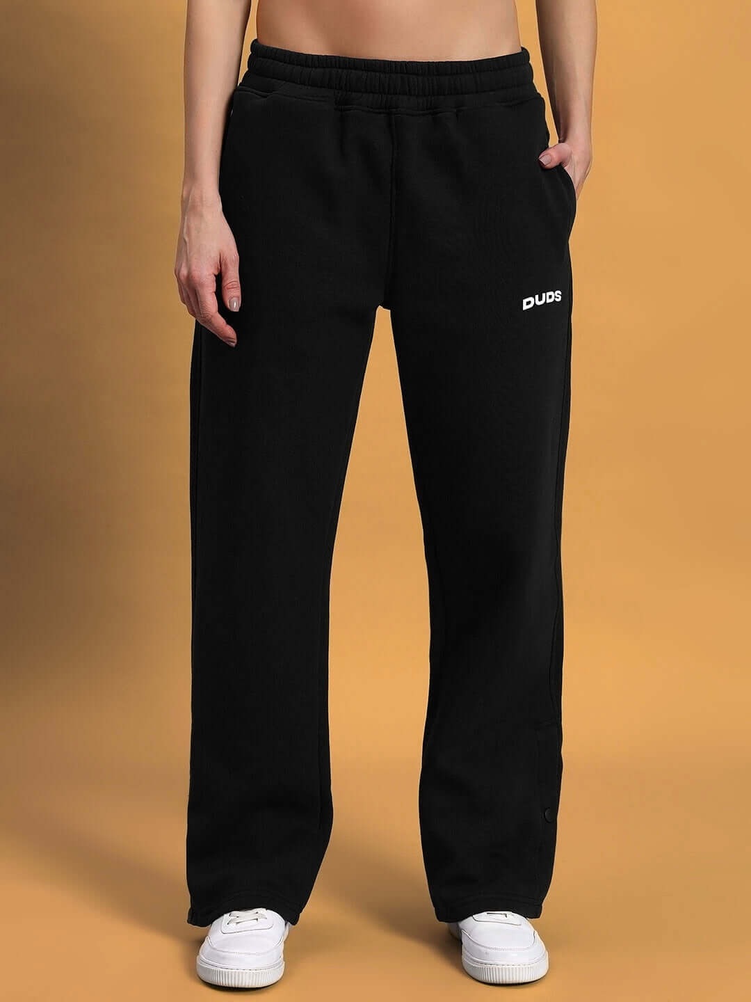 Model wearing WOMEN'S SOOTY FLEECE CARGO PANT BLACK with DUDS logo, featuring cozy fit for casual wear