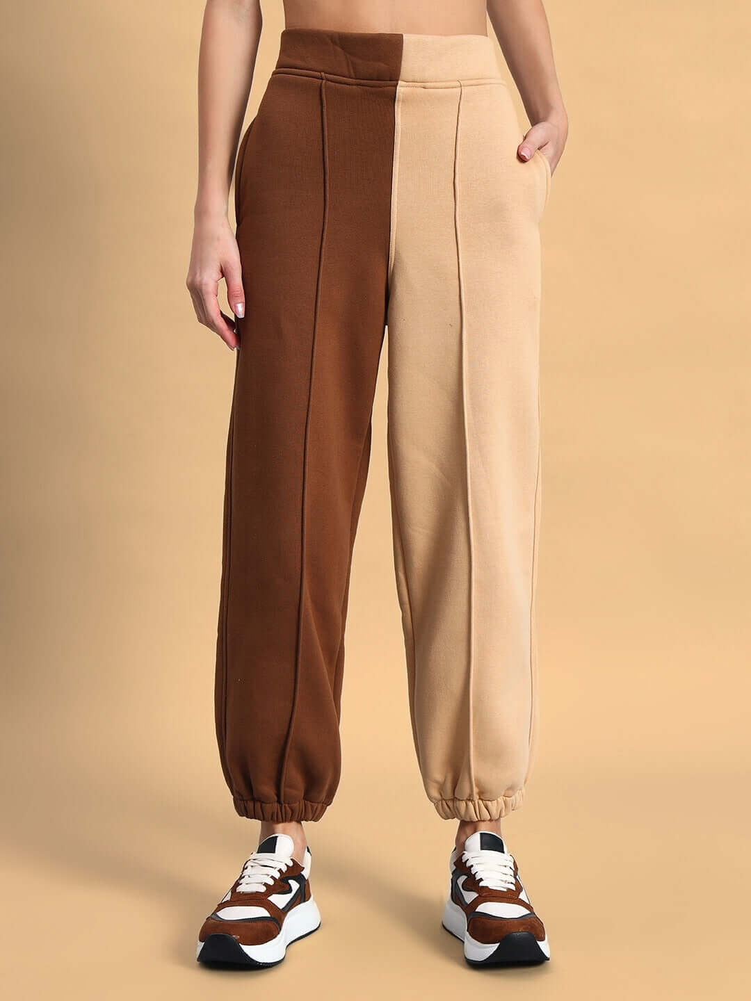Woman wearing beige-brown Sophia co-ord set, showcasing relaxed fit pants with split color design, paired with stylish sneakers.