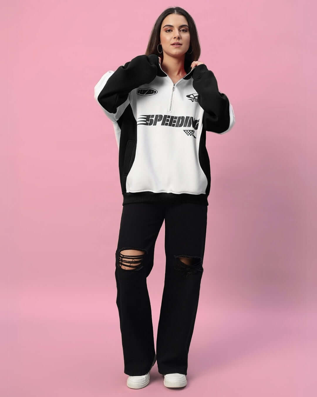 Woman wearing the Women's Speeding Colorblock Jacket in black with a bold pattern, styled with distressed jeans, on a pink background.