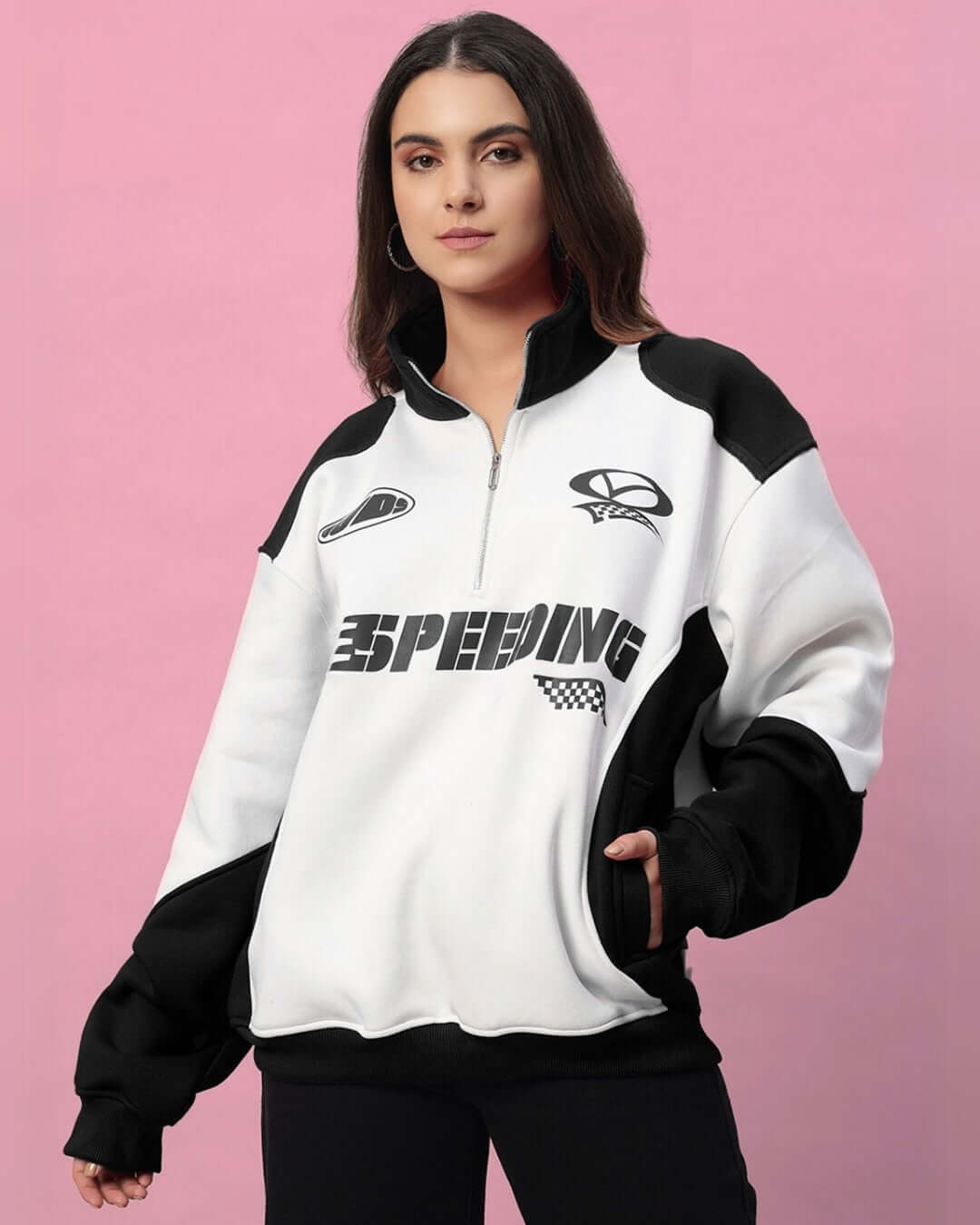 Woman wearing a modern black and white colorblock jacket with bold 'Speeding' text, featuring relaxed fit and premium fleece material.