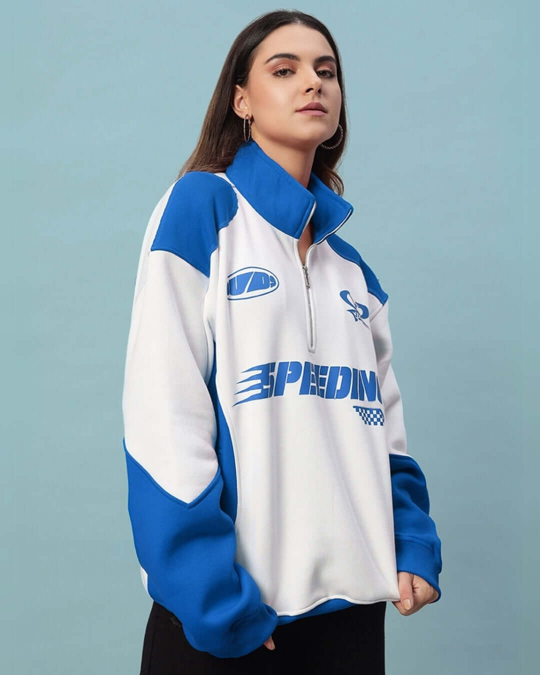 Woman wearing blue and white colorblock jacket with 'Speeding' logo, showcasing sporty style and comfort.