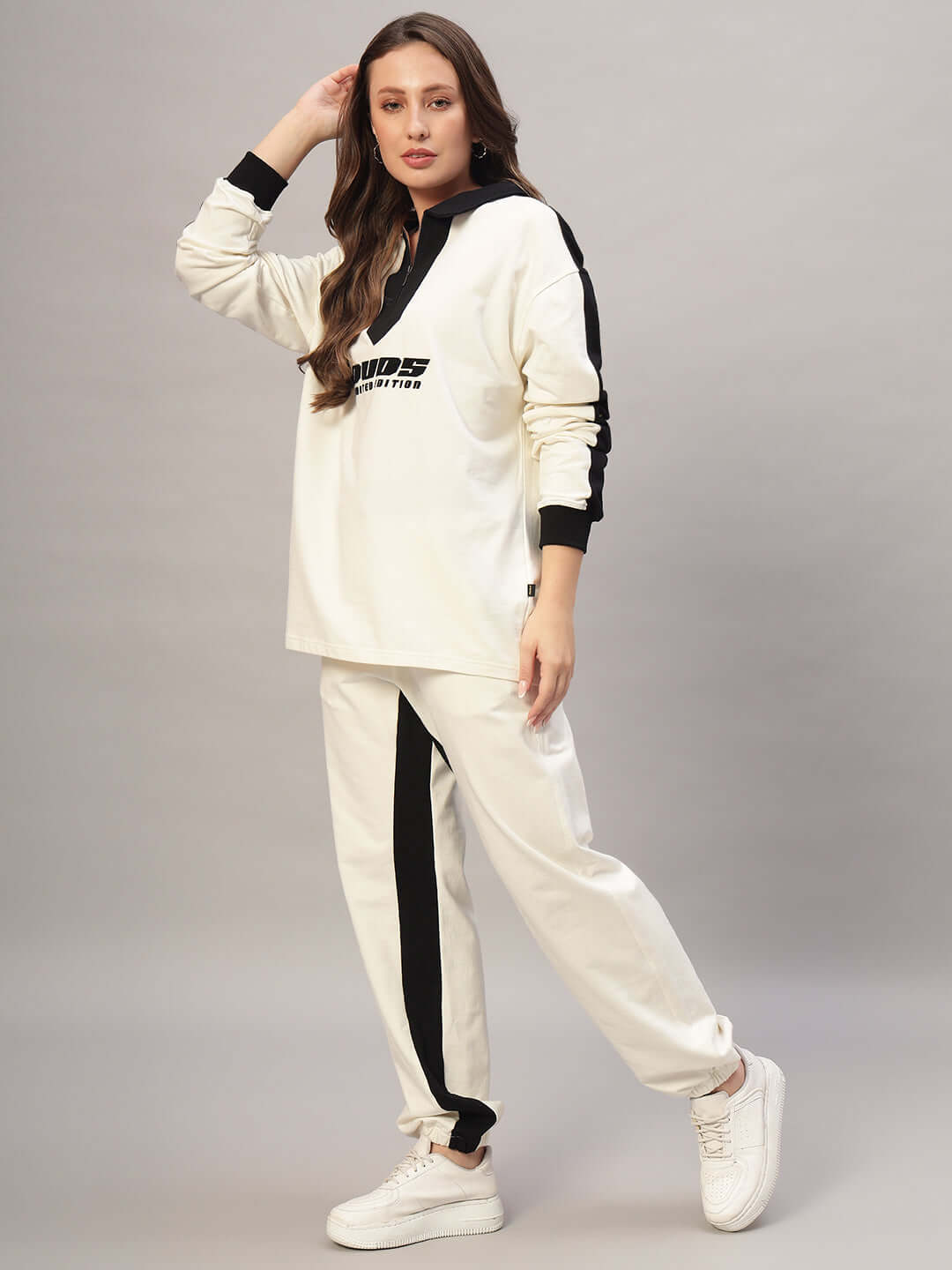 Woman wearing WOMEN SPLINTER OVERSIZED CO-ORD SET OFF WHITE BLACK, featuring oversized sweatshirt and joggers for chic street style.