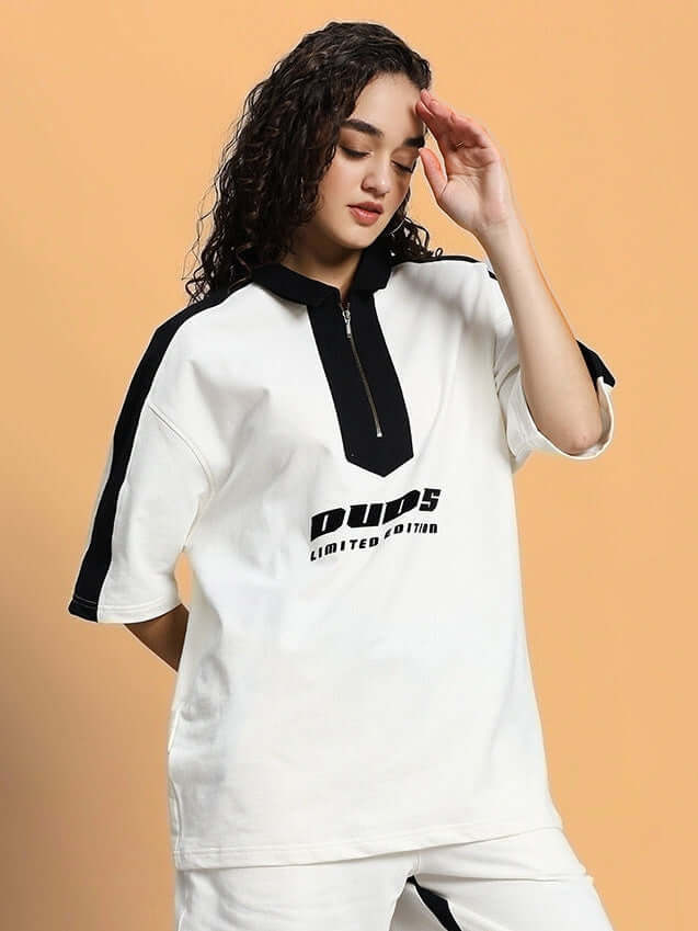Woman wearing oversized white t-shirt with black accents, showcasing trendy casual fashion.