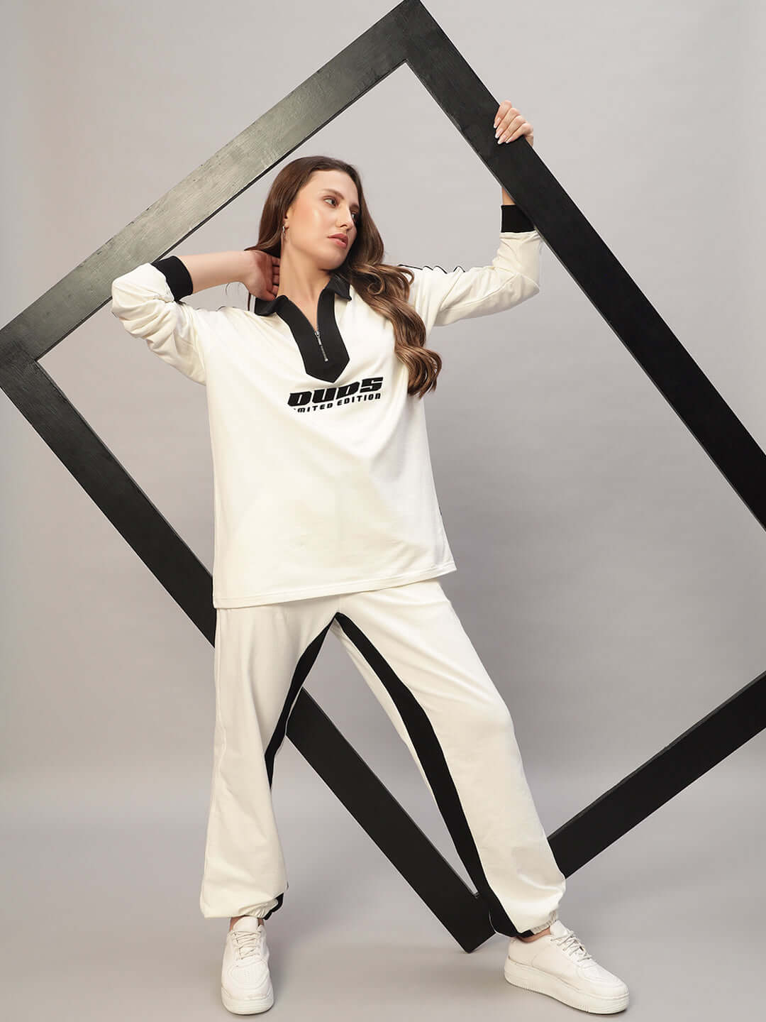 Model wearing WOMEN SPLINTER OVERSIZED CO-ORD SET OFF WHITE BLACK, featuring oversized sweatshirt and joggers.