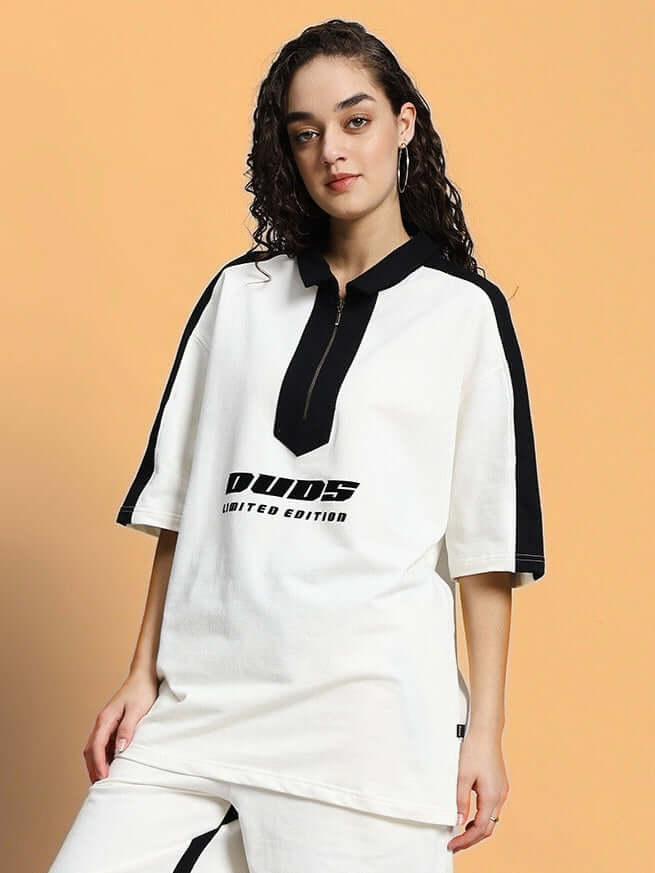 Model wearing women's oversized off-white T-shirt with black accents and text print, made of premium cotton fabric, 240 GSM, by Color By Colours.