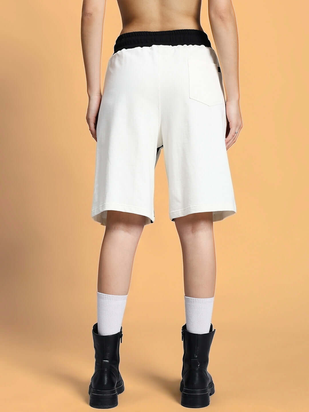 Back view of women's off white regular fit shorts with elastic waistband and black detailing.