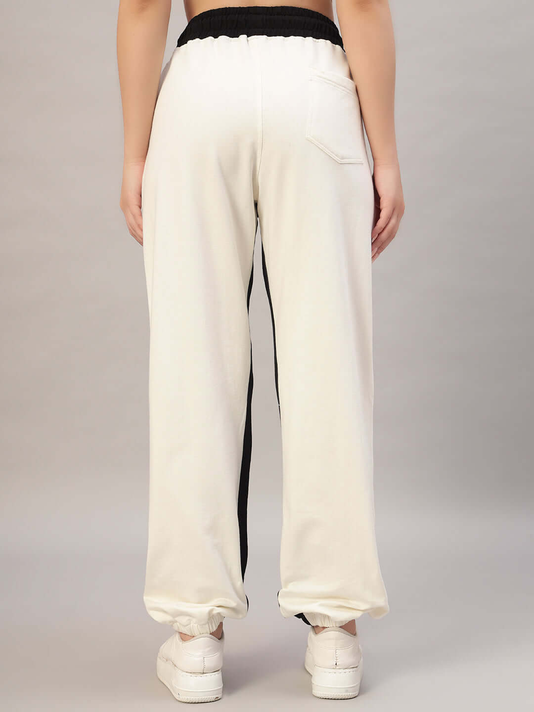 Back view of off-white and black women's joggers with side contrast, worn by a model.