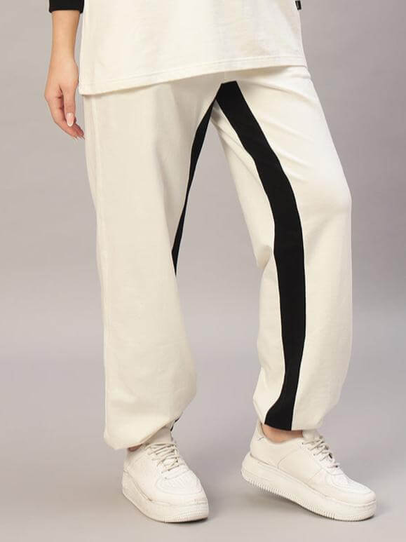 Women's off-white black contrast joggers by DUDS, showcasing side stripe detail and relaxed fit design.