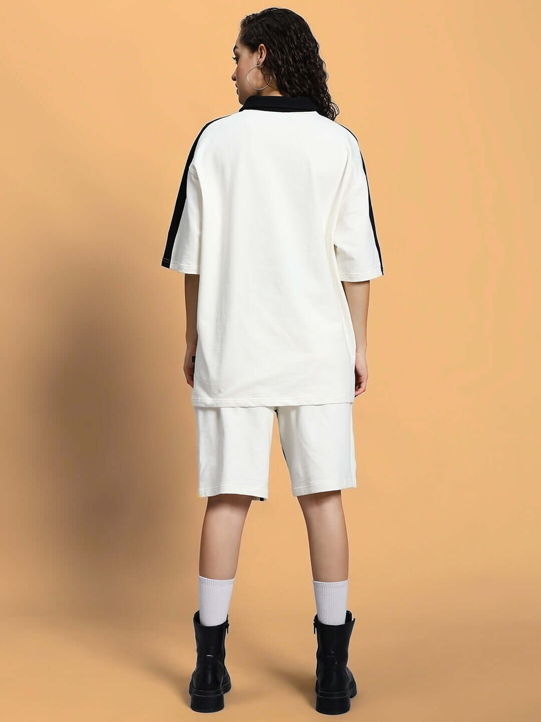 Back view of a woman wearing an off-white summer co-ord set, featuring a loose shirt and shorts, crafted from premium cotton terry lycra.