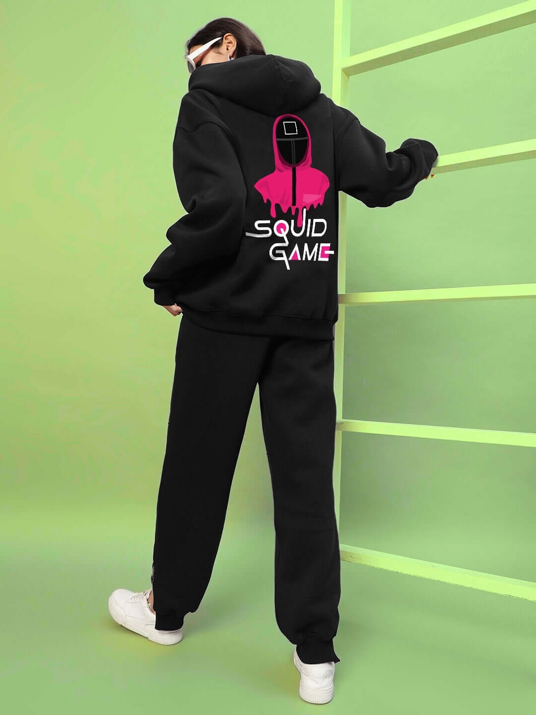 Back view of WOMENS SQUID GAME OVERSIZED HOODIE BLACK with bold graphic, styled for contemporary streetwear fashion.