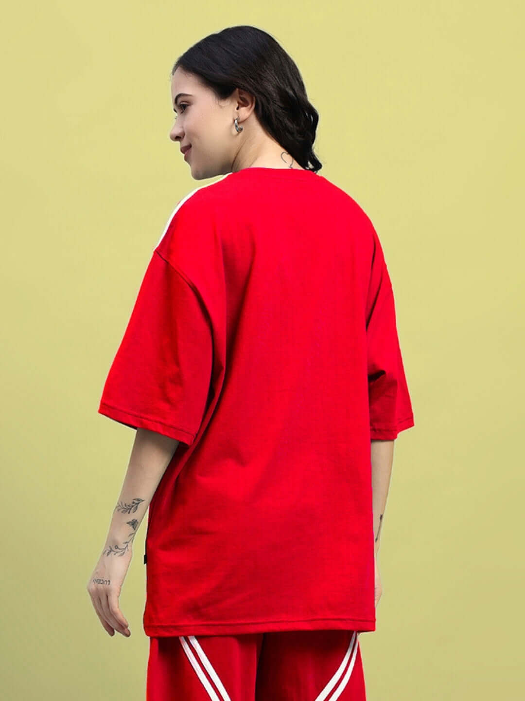 Women wearing red oversized t-shirt with star design, made of premium cotton and elastane fabric, shown from the back.
