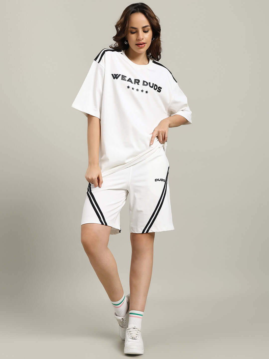 Woman wearing WOMEN'S STAR JUMPER REGULAR FIT SHORTS OFF WHITE with a top, showing a casual and stylish outfit.