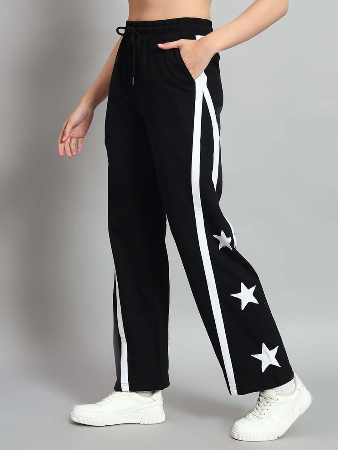 Women's black joggers with star design, side stripe, worn by model, made by DUDS, customizable fit, 7-10 days dispatch.