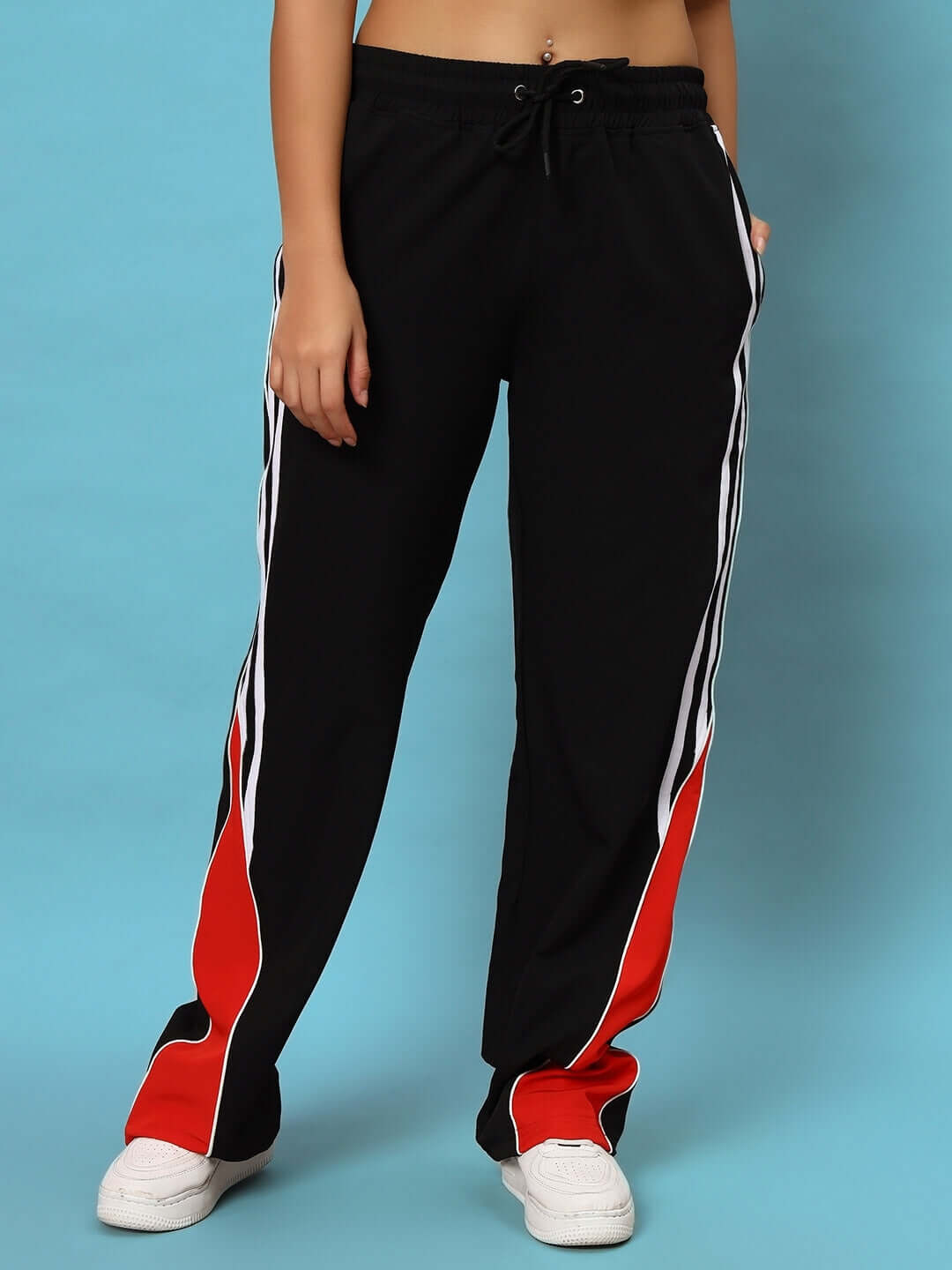 Women's black string parachute cargo pants with customizable fit, red side panels, and white stripes, showcased against a blue background.