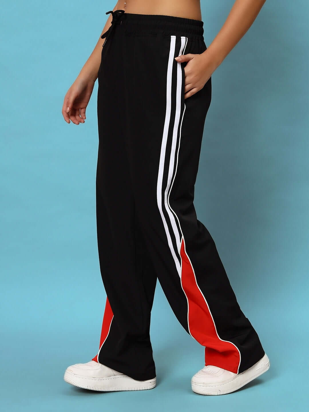 Model wearing black women's string parachute cargo pants with red and white accents, showcasing relaxed fit and adjustable waist.