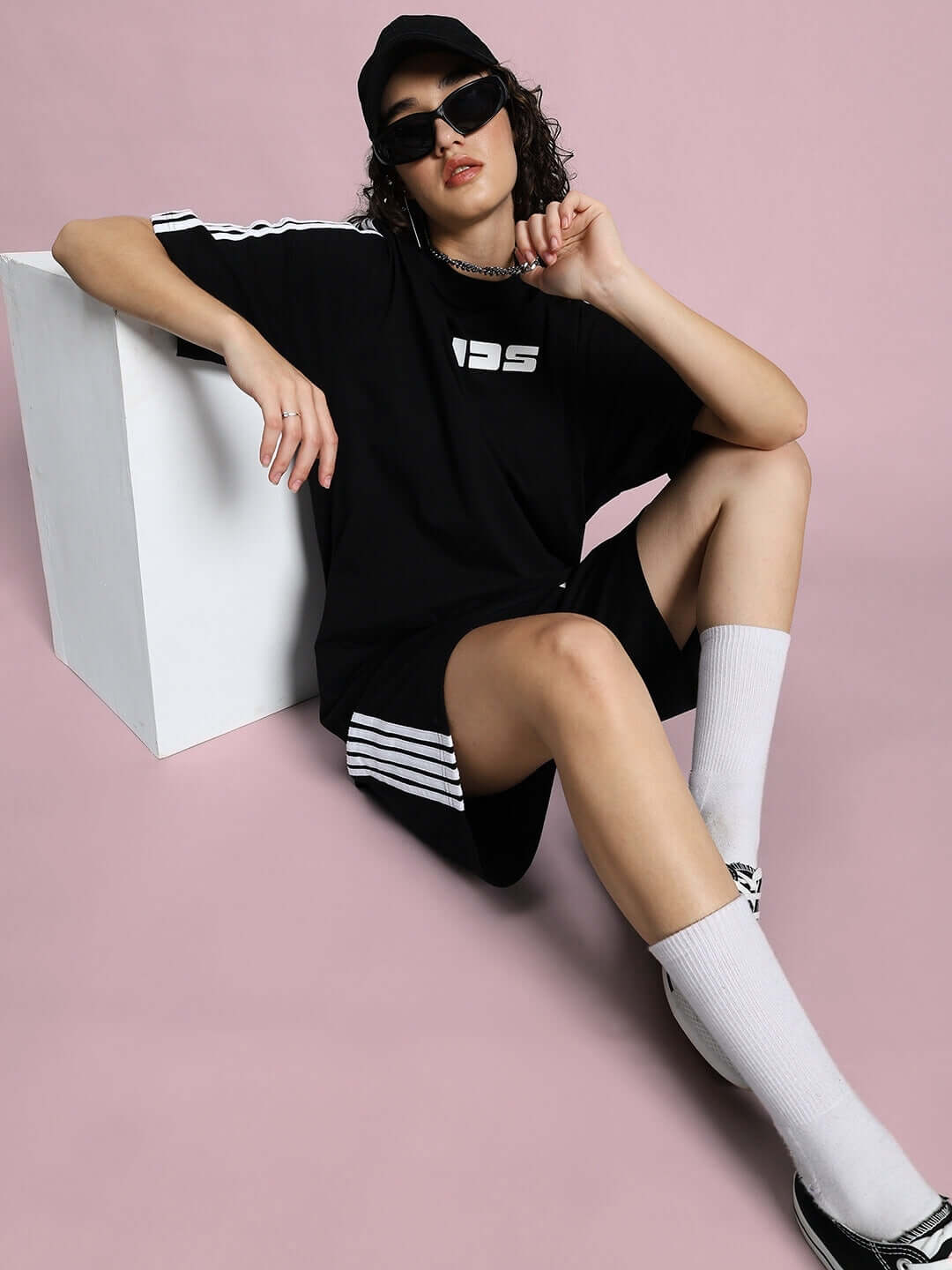 Person wearing WOMEN'S PARKA SUMMER CO-ORD SET BLACK, seated on the floor, showcasing the stylish black co-ord set for a chic summer look.