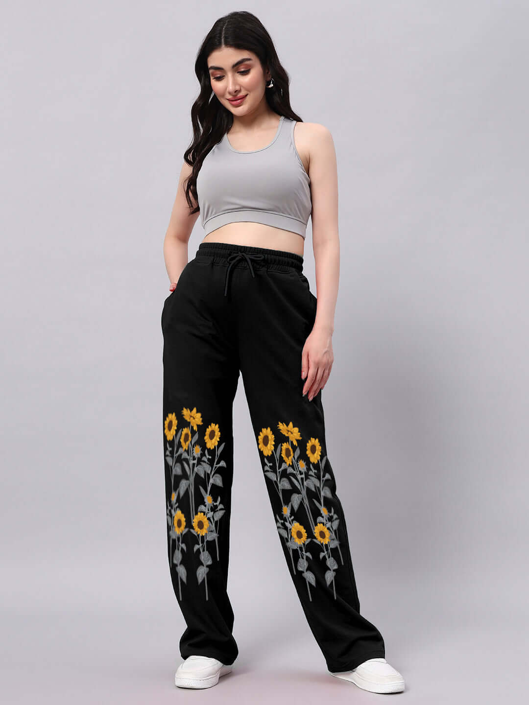 Woman wearing black relaxed-fit jogger pants with sunflower design, showcasing casual style and comfortable fit.