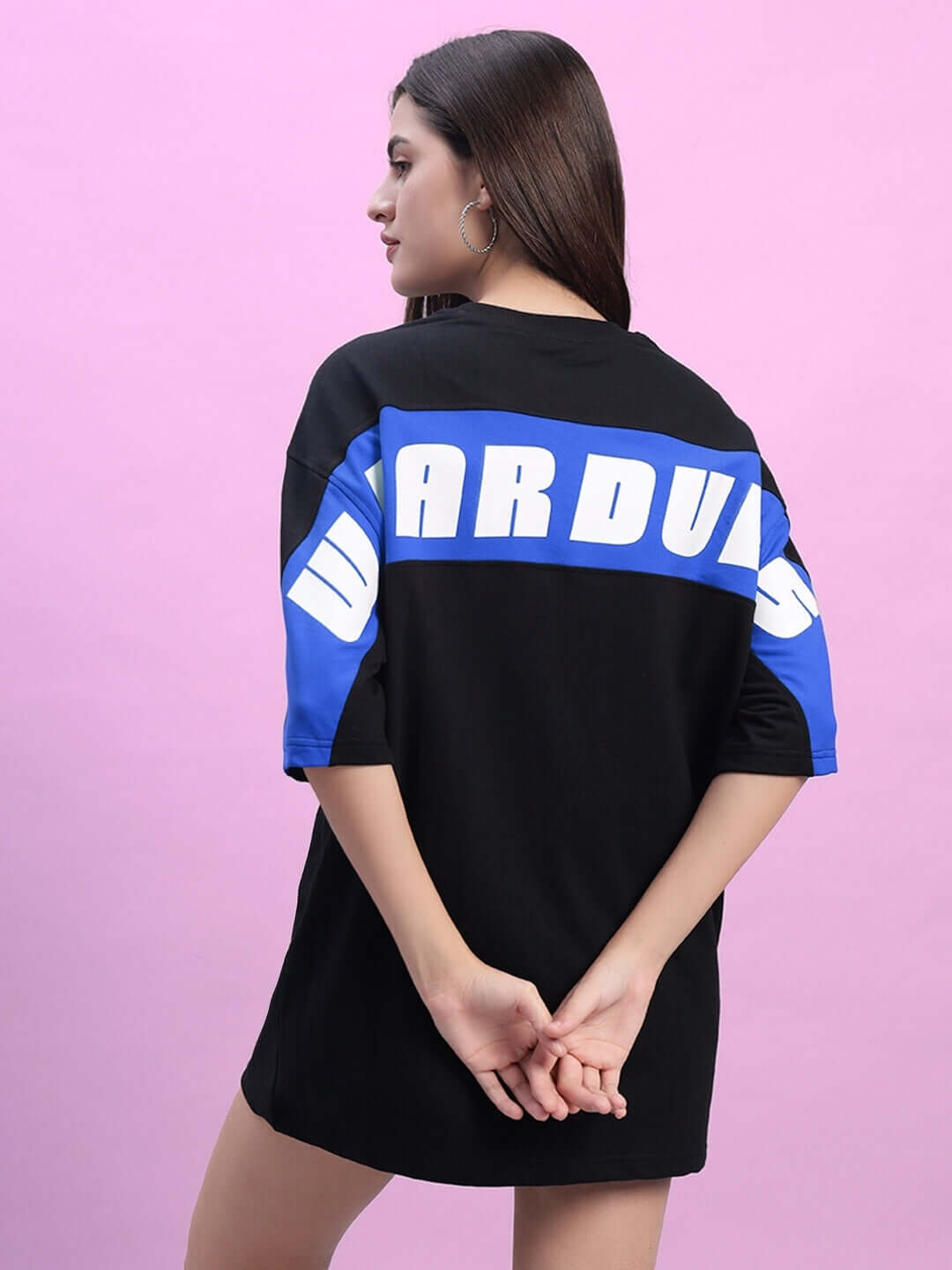 Model wearing oversized black-blue women's t-shirt with bold back design, made from premium cotton blend fabric.