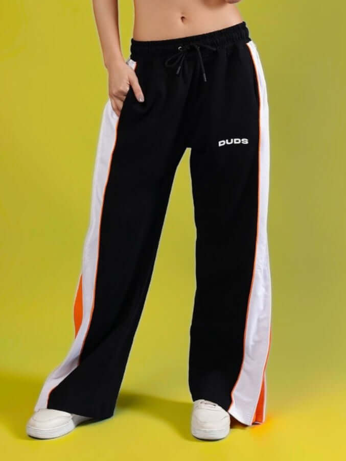 Women's Triumph black joggers with multi zippers, featuring orange and white stripes, custom fit available from DUDS.