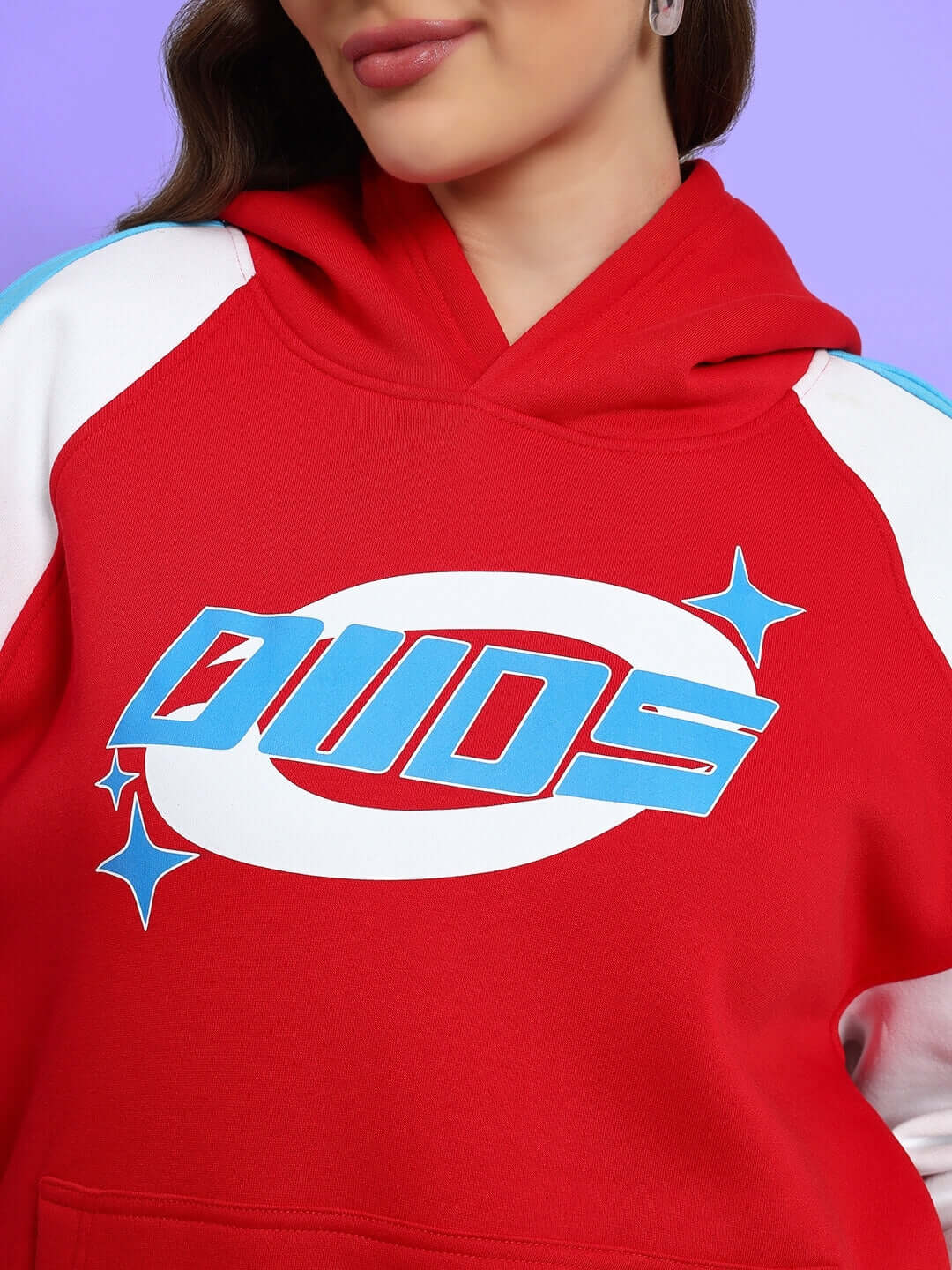 Woman wearing red DUDS colorblock hoodie, featuring a bold logo design, close-up view. Fashionable custom-made women's co-ord.