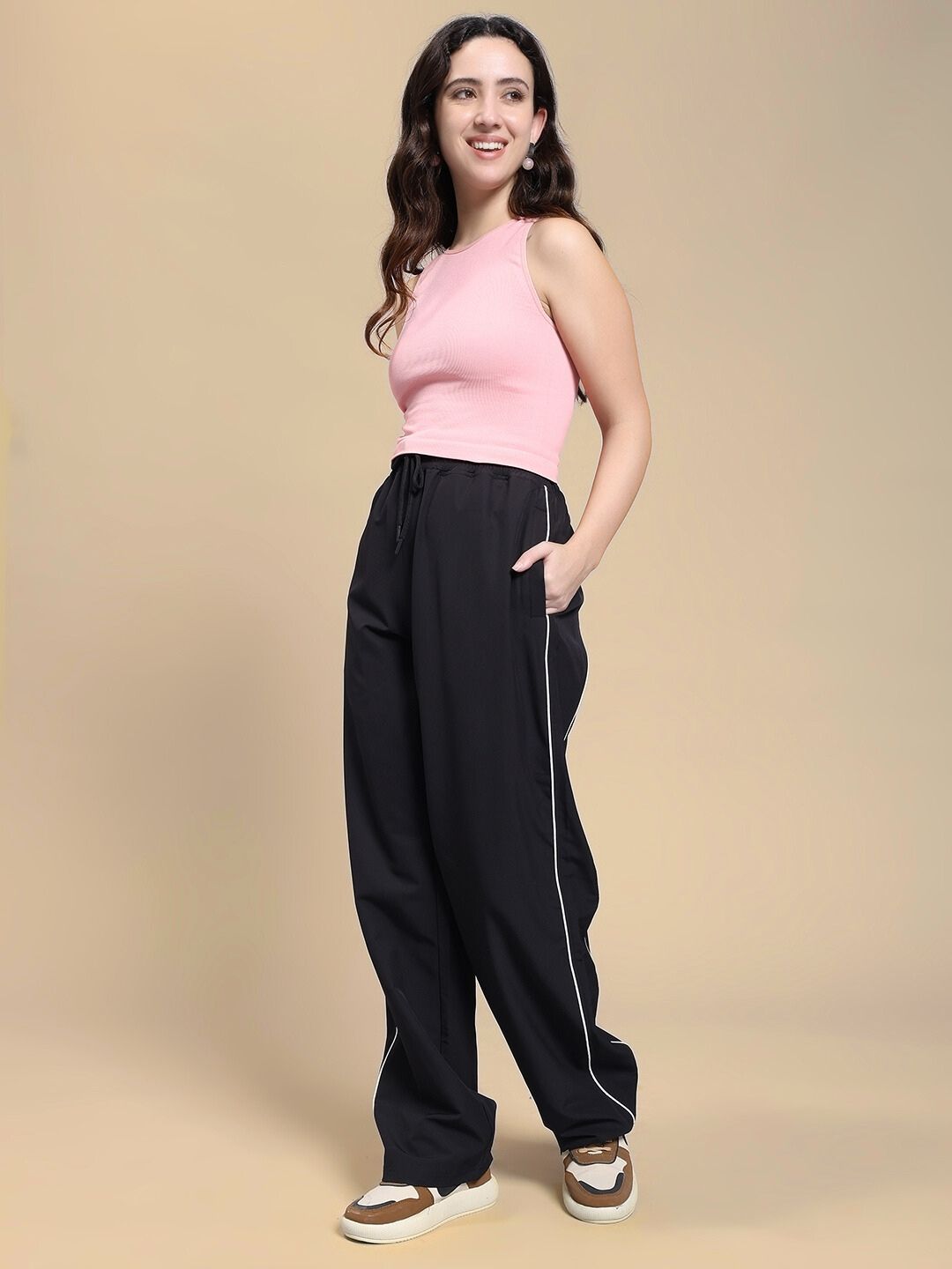 Woman wearing WOMEN TURBO TRACK RELAXED-FIT JOGGERS BLACK with a pink top for effortless street-style fashion.