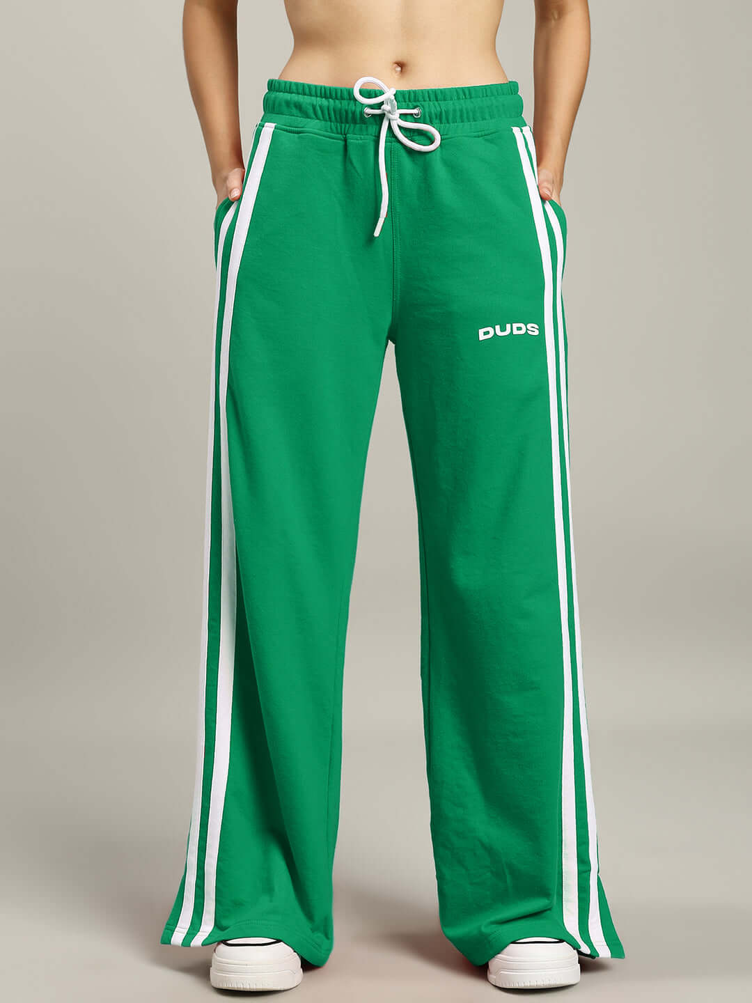 Model wearing women's green joggers with white stripes by DUDS, featuring relaxed fit and customizable sizing options.