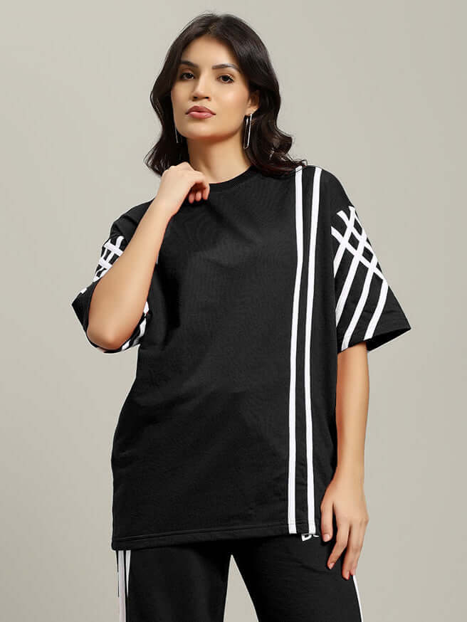 Women's black oversized T-shirt with white stripes, made from premium cotton French terry, showcased by model, Color By Colours.
