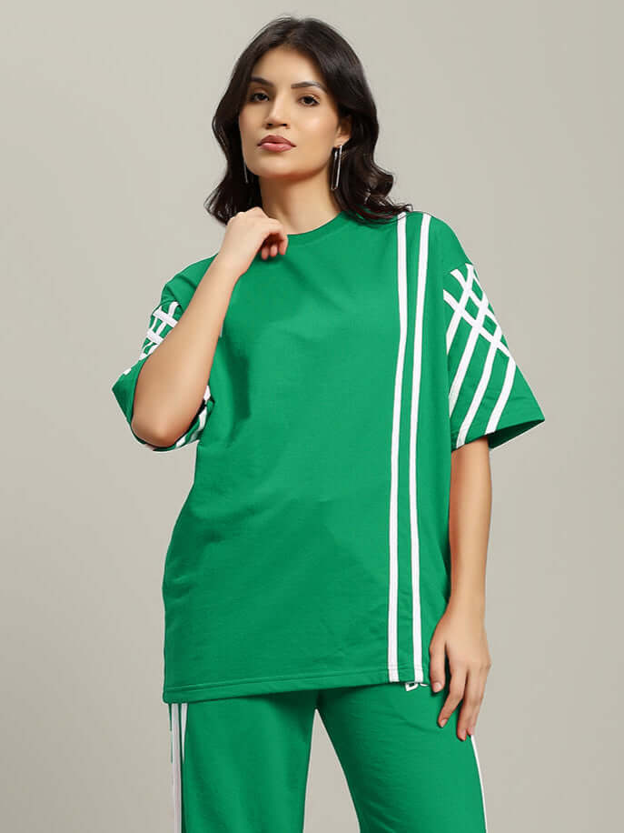 Woman wearing green oversized t-shirt with white stripes, made from premium cotton and elastane blend. Stylish casual wear.