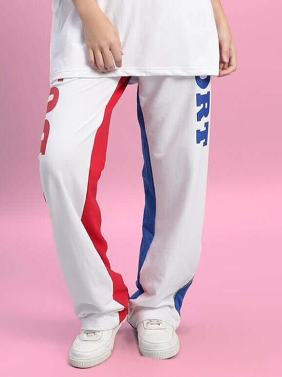 Women's Urban Drift Relaxed Fit Joggers in white with red and blue stripes, showcasing a sporty design against a pink backdrop.