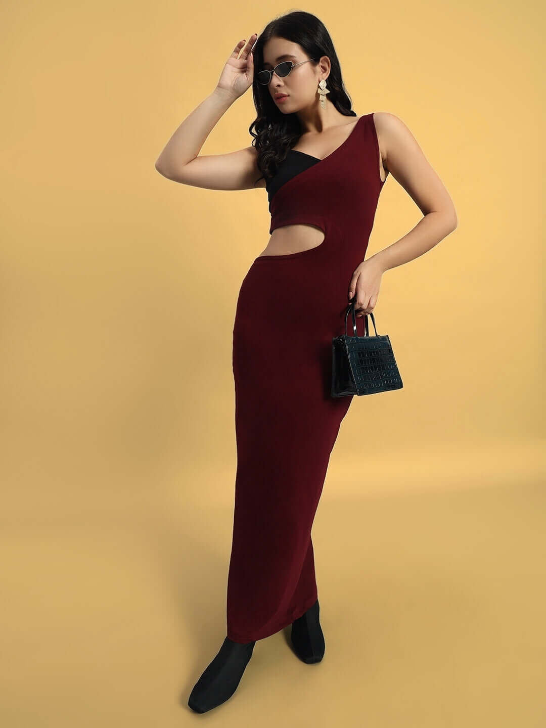 Elegant woman modeling in a maroon Valencia Lycra dress featuring a stylish cutout, ideal for chic occasions, made of polyester and spandex.