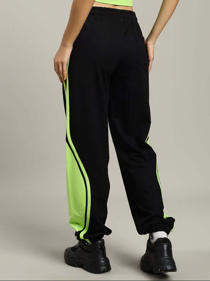 Woman wearing Women's Vector Baggy Joggers in black and neon green, showcasing comfortable fit and stylish design.